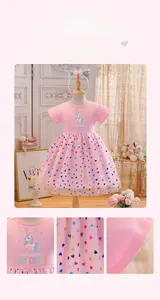 Detailed close-up of pink girls unicorn dress with colorful rainbow sequin heart pattern