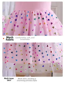 Détail d'une robe tutu rose avec des paillettes cœur colorées et un tissu en tulle multicouche
