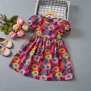 Detailed flat lay of floral print girls dress with puff sleeves and wood hanger