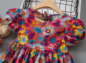 Detailed close-up of girls floral cotton summer dress with sunflower patterns and puff sleeves