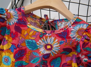 Detail of pink floral cotton girls dress showing neckline with yellow sunflower prints