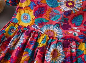 Detail of floral print fabric with ruched design on red cotton summer dress