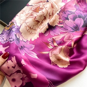 Silk-like satin scarf featuring vibrant purple peony patterns and a glossy texture