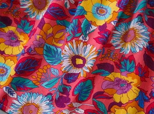 Close-up of vibrant sunflower floral print fabric on a soft cotton girls' dress