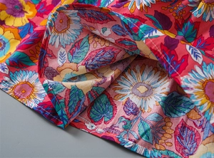 Close-up of vibrant sunflower print fabric and precise hem stitching on girl's dress