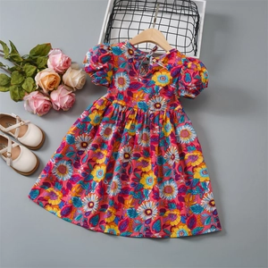 Flat lay of floral cotton girl's dress with puff sleeves and vibrant flower print