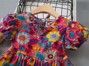 Detail of red floral girl dress with puff sleeves and ribbon tie at the back