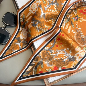 Elegant orange silk scarf with traditional floral patterns and satin texture finish