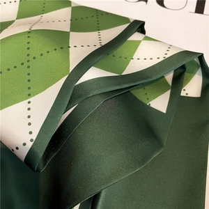 Diamond pattern green silk scarf with diagonal fold texture and smooth satin finish