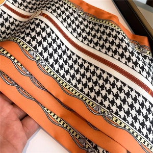 Houndstooth scarf with gold chain print in vibrant orange and black silk texture