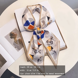 Detailed view of floral silk scarf tied in a bow over a magazine with size info
