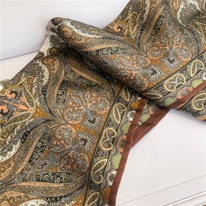 Detailed view of the paisley print and silky texture of the narrow neck scarf
