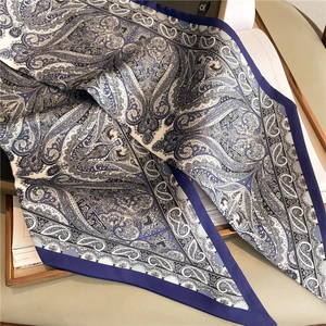 Blue and white paisley print satin silk scarf with deep navy borders in a stylish stack