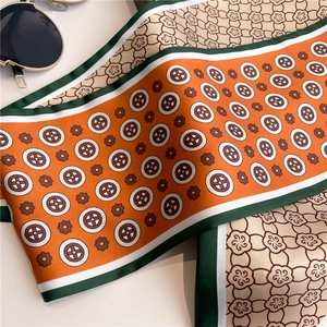 Detail of a thin silk scarf with vintage floral patterns and green contrast edges