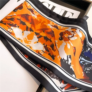 Chic oil painting silk scarf with abstract orange and brown patterns on a magazine