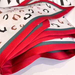 Close-up of leopard print silk scarf with red and green borders on a fashion magazine