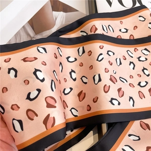 Close-up of peach leopard print silk scarf with black piping on vogue magazine