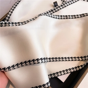 Detail of satin silk scarf with houndstooth edge and smooth draping texture