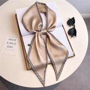 Detail of champagne narrow scarf with houndstooth borders on white magazine