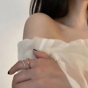 Minimalist silver geometric criss-cross open ring worn on model with elegant styling