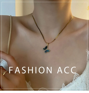 Detail of golden butterfly pendant with abalone shell on a snake chain necklace