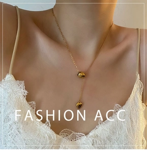 Detailed view of gold heart pendant necklace with y-shaped chain on model