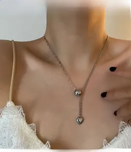 Macro shot of silver titanium steel heart pendant necklace showing delicate chain drape