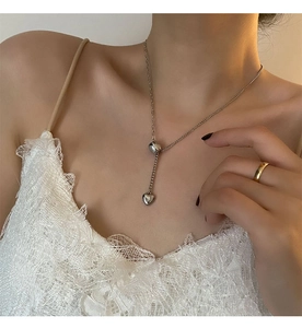 Silver Y-shaped heart necklace detail showing a sliding pendant on an elegant model