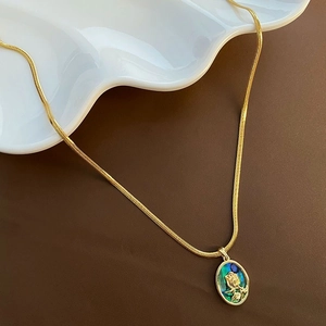 Détail du collier à maille serpent dorée avec pendentif rose en relief et nacre abalone