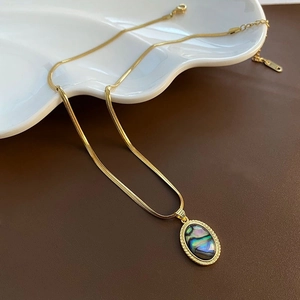 Détail du collier chaîne serpent dorée avec pendentif ovale en nacre d'abalone irisée