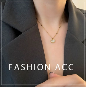 Vue détaillée du collier Ruyi doré avec pierre œil de chat sur un blazer noir