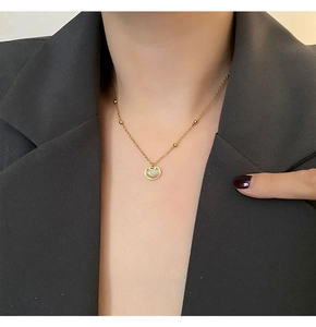 Détail du collier pendentif serrure Ruyi dorée avec incrustation blanche