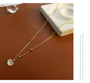 Détail du collier cadenas Ruyi doré avec œil de chat sur cuir et porcelaine élégante