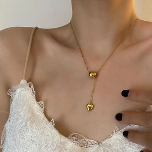 Titanium steel gold heart pendant necklace shown on a model with an adjustable clasp