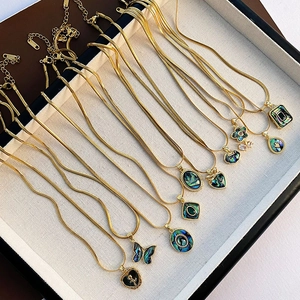 Parure de colliers en acier titane doré avec pendentifs en nacre d'abalone variés