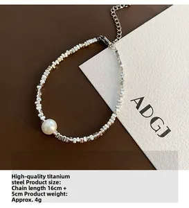 Détail du bracelet en acier titane avec perle ronde, perles en métal et fermoir mousqueton