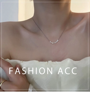 Dettaglio della collana in argento con perle bianche disposte in un arco elegante