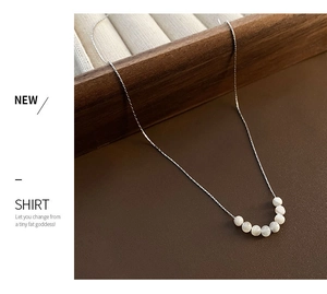 Dettaglio macro della collana in titanio argento con sette eleganti perle di conchiglia