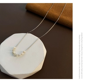 Dettaglio della collana argentata con sette perle di conchiglia su supporto in velluto