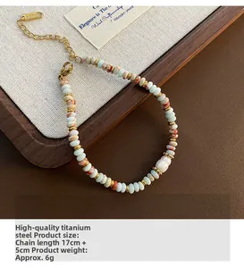 Détail du bracelet en perles de pierre avec chaîne ajustable en acier titane doré