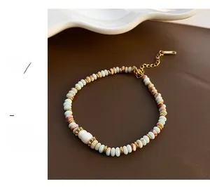 Détail d'un bracelet de perles colorées avec perle naturelle et chaîne d'extension dorée