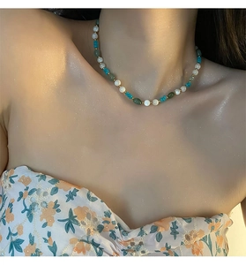 Close-up of handmade natural stone choker with strawberry crystal and pearl beads
