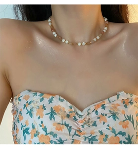 Detail of natural stone strawberry crystal beaded necklace with gold metal spacers