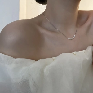 Elegante collana in acciaio al titanio con ciondolo in perla indossata da una modella