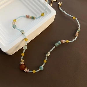Collier de perles de pierres fines multicolores avec pendentif central orange et perles bleues