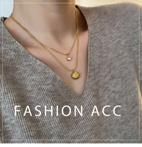 Close-up of double-layered gold necklace with zircon and Fu character pendant on model