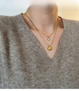Close-up of double-layer gold necklace with zirconia and Fu character pendant on model