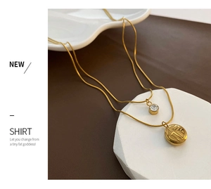 Detail of a double-layered gold titanium necklace with Fu character and zircon pendant