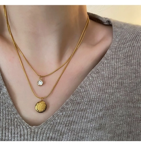 Detailed view of double-layer gold necklace featuring zircon and Fu character pendant