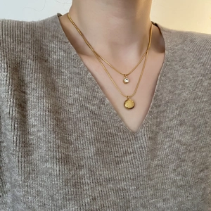 Double-layered gold necklace with clear crystal and Fu character pendant on steel chain